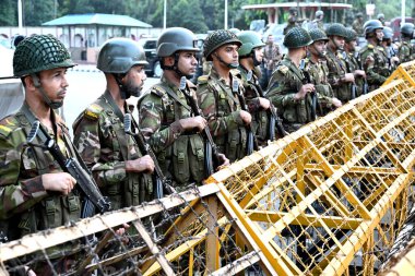 Ordu askerleri, 22 Ekim 2024 'te Dhaka' da eski başbakanın istifası üzerine Cumhurbaşkanı Muhammed Şahabuddin 'in istifasını talep eden bir gösteri düzenlerken cumhurbaşkanının evinin önünde nöbet tutuyorlar.