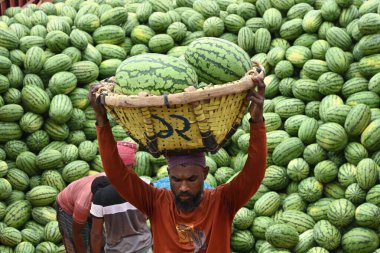 İşçiler 21 Mart 2025 'te Dhaka, Bangladeş' teki Buriganga Nehri 'nin kıyısındaki bir tekneden karpuz indirirler. Ülkenin dört bir yanından yüzlerce meyve tüccarı yaz mevsiminde meyvelerini toptan satmak için başkente geldi.
