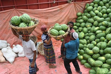 İşçiler 21 Mart 2025 'te Dhaka, Bangladeş' teki Buriganga Nehri 'nin kıyısındaki bir tekneden karpuz indirirler. Ülkenin dört bir yanından yüzlerce meyve tüccarı yaz mevsiminde meyvelerini toptan satmak için başkente geldi.