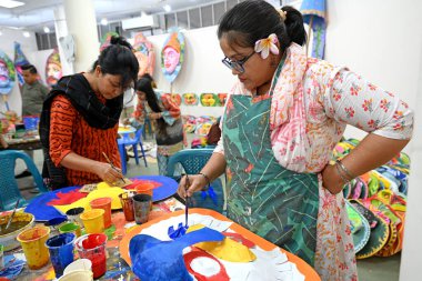 Dhaka Üniversitesi Güzel Sanatlar Fakültesi öğrencisi, Bangladeş 'in Dhaka şehrinde 1432 yılını kutlamak için renkli maskeler boyuyor.. 