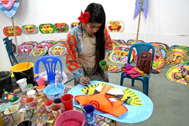 Dhaka Üniversitesi Güzel Sanatlar Fakültesi öğrencisi, Bangladeş 'in Dhaka şehrinde 1432 yılını kutlamak için renkli maskeler boyuyor.. 