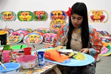 Dhaka Üniversitesi Güzel Sanatlar Fakültesi öğrencisi, Bangladeş 'in Dhaka şehrinde 1432 yılını kutlamak için renkli maskeler boyuyor.. 