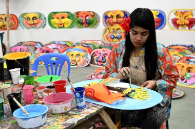 Dhaka Üniversitesi Güzel Sanatlar Fakültesi öğrencisi, Bangladeş 'in Dhaka şehrinde 1432 yılını kutlamak için renkli maskeler boyuyor.. 