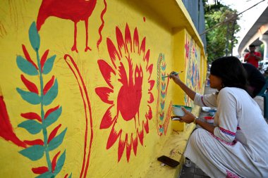 Dhaka Üniversitesi Güzel Sanatlar Fakültesi öğrencisi, Bangladeş, Dhaka 'daki Bengali Yeni Yıl kutlamaları öncesinde 9 Nisan 2025' te bir dekoratif duvar resmine son rötuşlarını yapıyor.. 