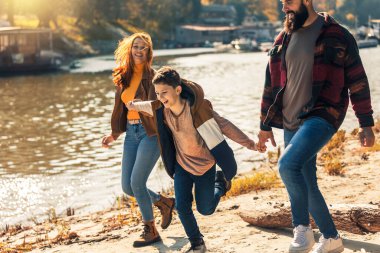 Ebeveynler ve oğulları nehir kenarında yürüyor kırsalda tatil yapıyorlar.