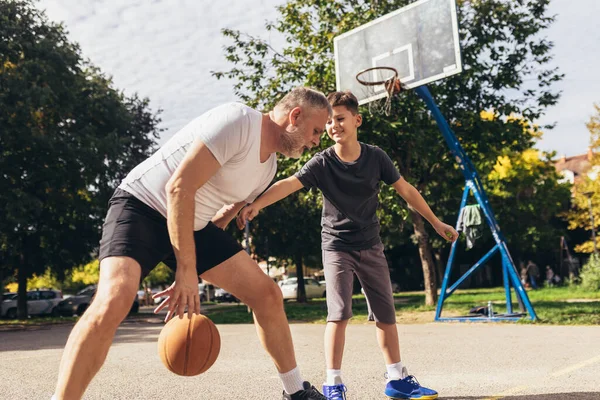 成熟した男は息子とバスケットボールをする — ストック写真