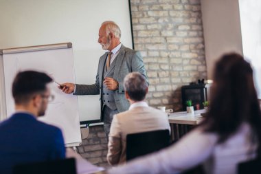İşletme atölyesi sözcüsü ofisteki meslektaşlarına iş hakkında bir sunum yapıyor..