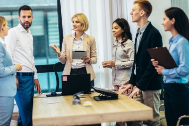 Office colleagues having discussion during meeting in conference room. Group of men and women in conference room.
