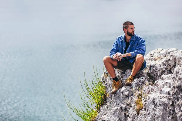 髭の男は自然に一人でリラックスしている 旅行ライフスタイルのコンセプト屋外での湖の風景 — ストック写真