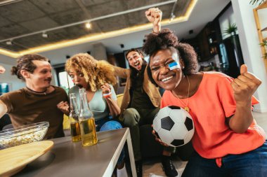 Genç bir grup televizyonda spor izliyor ve tezahürat yapıyor. Duygusal futbol hayranları evde futbol maçı izliyorlar. Boyalı Yüzlü Spor Hayranları TV 'de Kanepe İzleme Oyunu' nda oturuyor
