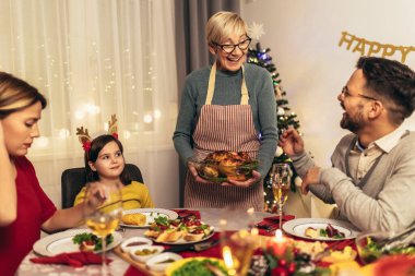 Mutlu çok nesilli aile evde birlikte yemek yiyor. Evde Noel yemeğinde aile.