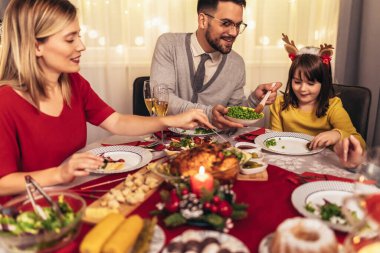 Mutlu bir aile evde birlikte yemek yiyor. Evde Noel yemeğinde aile.
