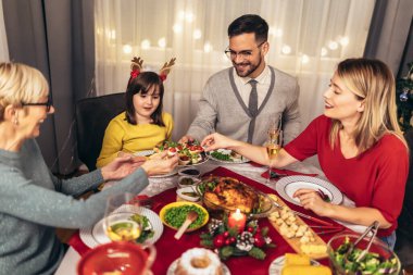 Mutlu çok nesilli aile evde birlikte yemek yiyor. Evde Noel yemeğinde aile.