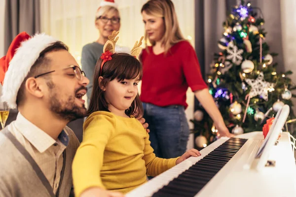 Οικογένεια Απολαμβάνοντας Μουσική Που Κόρη Τους Παίζει Στο Πιάνο Κατά — Φωτογραφία Αρχείου