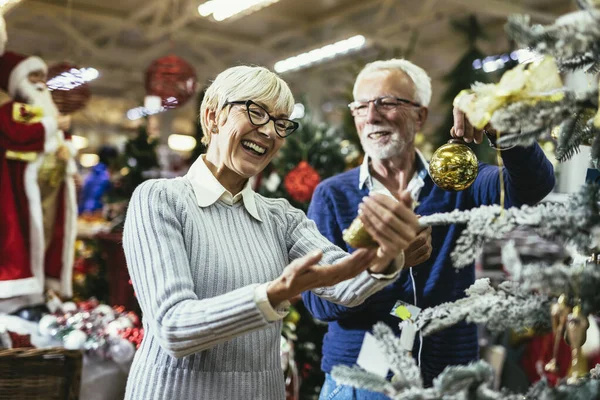 Ηλικιωμένο Ζευγάρι Στη Χριστουγεννιάτικη Αγορά Που Αγοράζει Παιχνίδια Και Μπάλες — Φωτογραφία Αρχείου