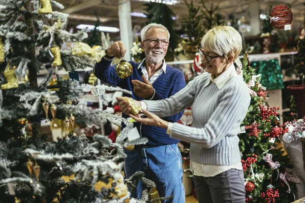 Ηλικιωμένο Ζευγάρι Στη Χριστουγεννιάτικη Αγορά Που Αγοράζει Παιχνίδια Και Μπάλες — Φωτογραφία Αρχείου