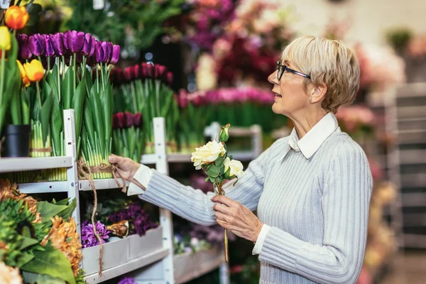 Starsza Pani Uśmiecha Się Trzymając Bukiet Kwiatów Ręku Kwiaciarni — Zdjęcie stockowe