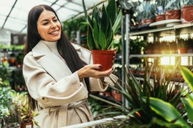 genç bir kadın çiçek Bahçe Merkezi satın 