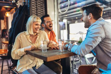 Mutlu arkadaşlar kafede harika vakit geçiriyorlar. Bir grup genç bir kafede oturup kahve içiyor..