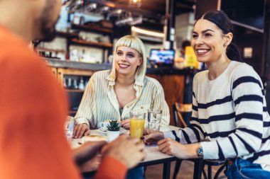 Mutlu arkadaşlar kafede harika vakit geçiriyorlar. Bir grup genç bir kafede oturup kahve içiyor..