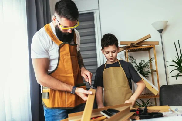 家で木板の家具を作る父と息子 — ストック写真