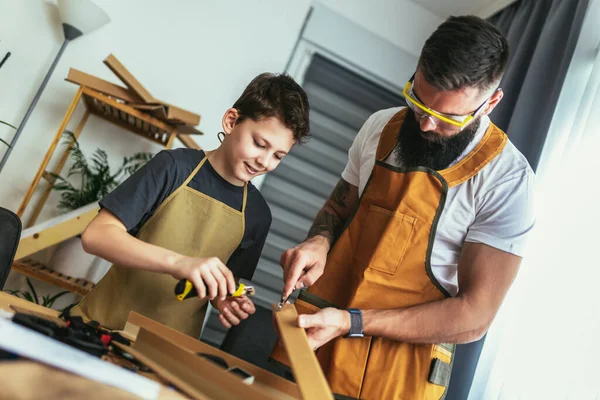 家で木板の家具を作る父と息子 — ストック写真