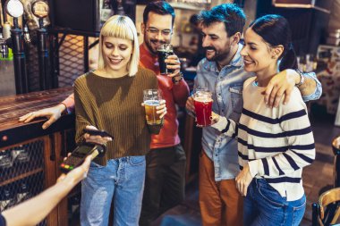 Bardaki çeşitli arkadaşlar hücresel aygıtla ödeme yapıyorlar