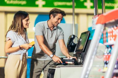 Banka kartı olan bir çift marketten ya da süpermarketten yiyecek alıyor.