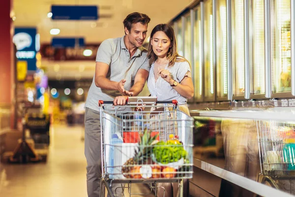 Happy Young Couple Bonding Each Other Smiling While Walking Supermarket — ストック写真