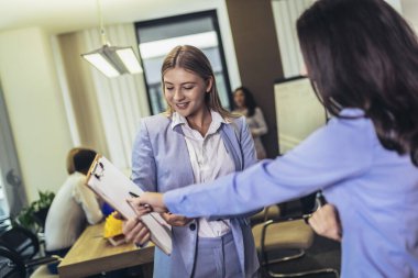Creative female executives meeting in an office and smiling.