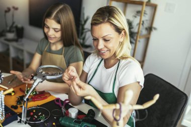 Anne ve kız aksesuar tasarımcıları stüdyo atölyesinde el yapımı mücevherler yapıyorlar. Moda, yaratıcılık ve el yapımı konsept.