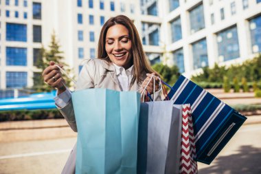 Çekici bir genç kadının şehirde alışverişe çıkması.