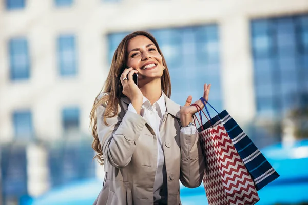 Şehirde Alışveriş Yaparken Cep Telefonunu Kullanan Çekici Genç Bir Kadın — Stok fotoğraf
