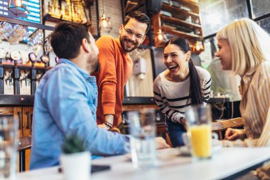Young people have a great time in a cafe. Friends sitting in a coffee shop, drinking coffee, and having fun together.