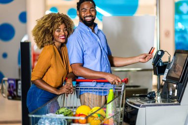 African American Couple with bank card buying food at grocery store or supermarket self-checkout