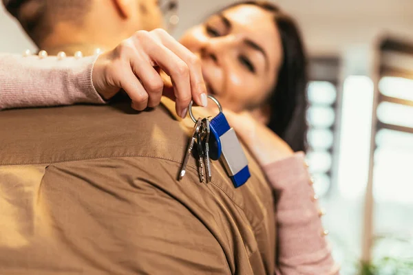 stock image Smiling couple hugging in new home.New life.Woman showing key of their new house.