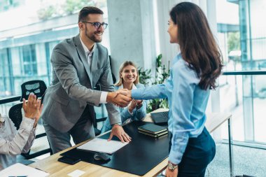 Business people shaking hands in the office. Group of business persons in business meeting. 