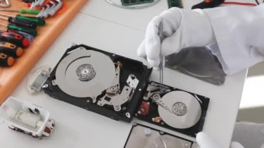 Mühendis bozuk bilgisayar sabit diskini tamir ediyor. Elektronik tamir atölyesi, teknoloji geliştirme konsepti
