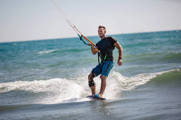 专业的风筝手做困难的把戏 一只雄性风筝在美丽的海浪背景下滑行 进行各种机动动作 — 图库照片