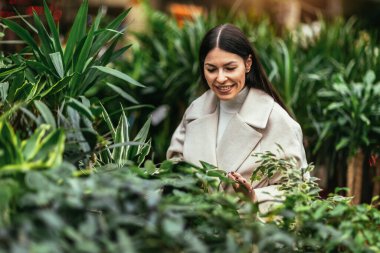 genç bir kadın çiçek Bahçe Merkezi satın 