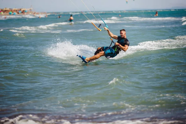 专业的风筝手做困难的把戏 一只雄性风筝在美丽的海浪背景下滑行 进行各种机动动作 — 图库照片
