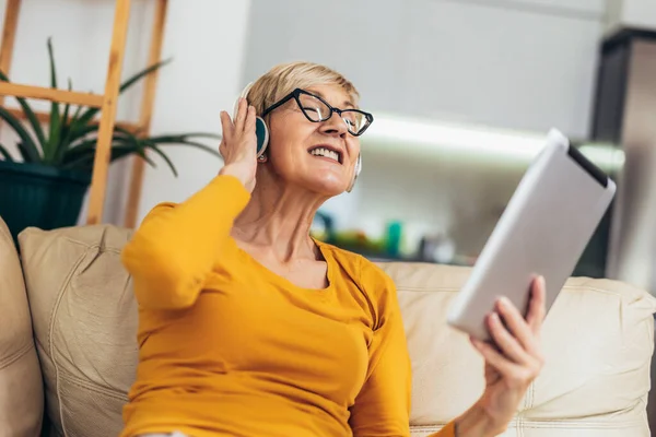 Happy Starší Žena Sluchátkách Úsměvem Pomocí Digitálního Tabletu Poslechu Hudby — Stock fotografie