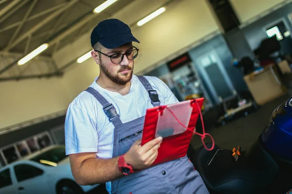 Homme Écrit Sur Presse Papiers Dans Garage Mécanicien Moto Professionnel — Photo