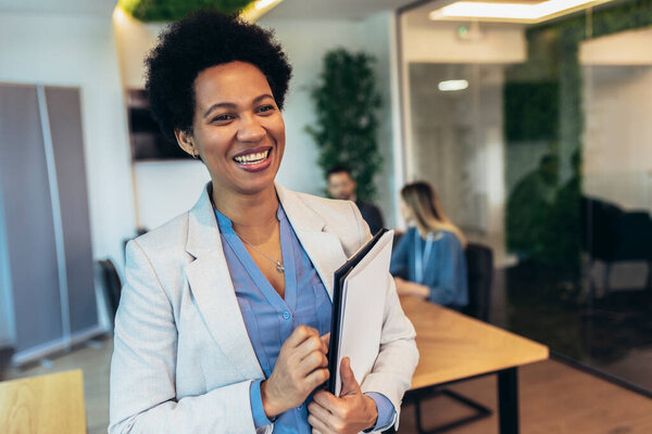 Портрет предпринимательницы, стоящей в офисе
. 