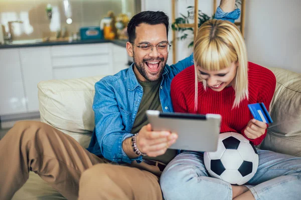 Nuori Pari Katsomassa Jalkapallo Peli Digitaalinen Tabletti Käyttämällä Luottokorttia Online — kuvapankkivalokuva