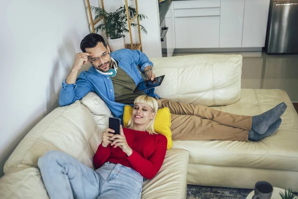 Schönes Paar Umarmt Sich Entspannt Auf Dem Sofa Und Nutzt — Stockfoto