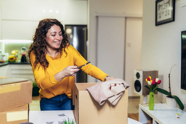 Woman make photo of cardboard box for storage. Concept organization, efficiency, or technology in storage management.