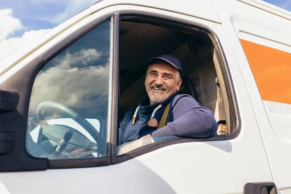 Portret Wesołego Kierowcy Dostawczego Wyglądającego Przez Okno Samochodu Dostawczego Białego — Zdjęcie stockowe
