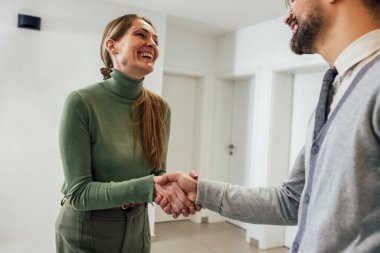 Shot of a young businessman shaking hands with a woman