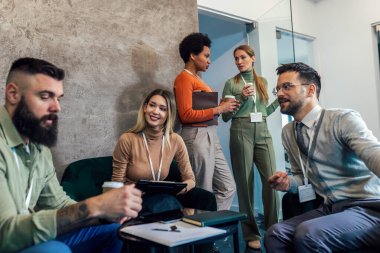 Ofis lobisinde çalışan iş adamları. İş adamlarından oluşan bir grup iş yerinde birlikte oturuyorlar.